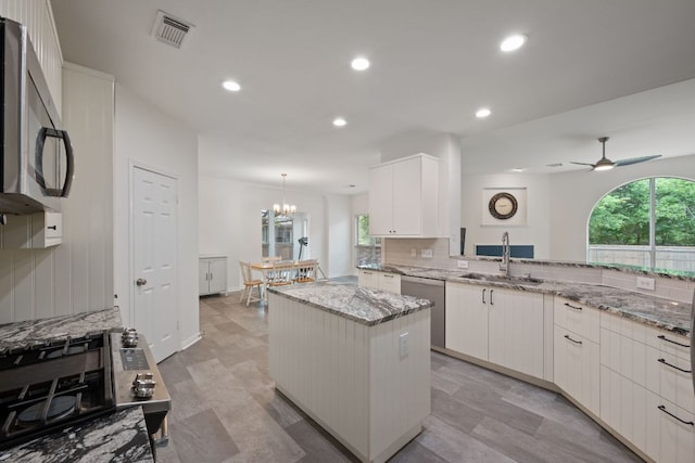 13305 Kinder Pass, Austin, TX 78727 - kitchen featuring a sink, stainless steel appliances, a kitchen island, light stone counters, and a ceiling fan