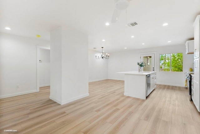 kitchen featuring visible vents, an island with sink, and light wood-style floors