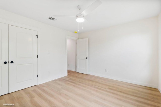 unfurnished bedroom with baseboards, a closet, light wood-type flooring, and visible vents