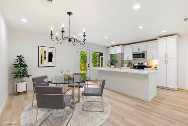 dining room with recessed lighting, a notable chandelier, visible vents, and light wood-type flooring
