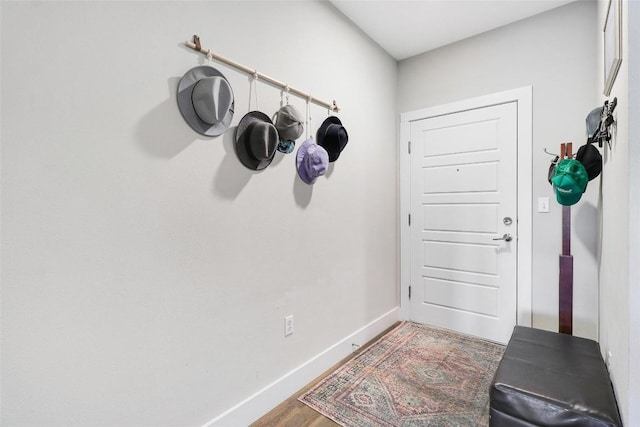 doorway with baseboards and wood finished floors