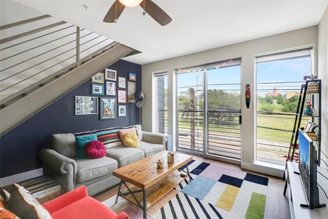 living room featuring ceiling fan, wood finished floors, and vaulted ceiling