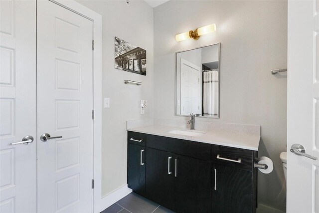 full bath featuring toilet, baseboards, tile patterned flooring, and vanity