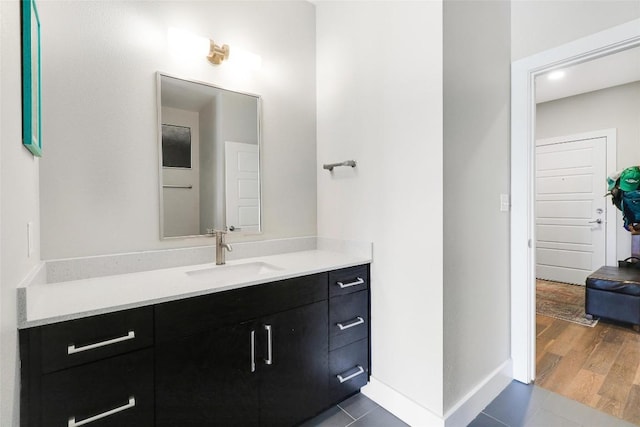 bathroom featuring vanity, baseboards, and wood finished floors