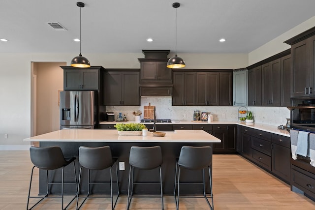 kitchen featuring stainless steel fridge with ice dispenser, decorative backsplash, and a breakfast bar