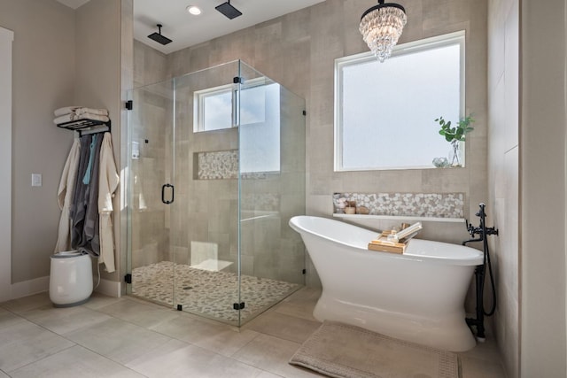 full bathroom with a freestanding tub, tile patterned flooring, a shower stall, and a chandelier