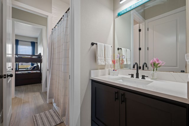 full bathroom with vanity and wood finished floors