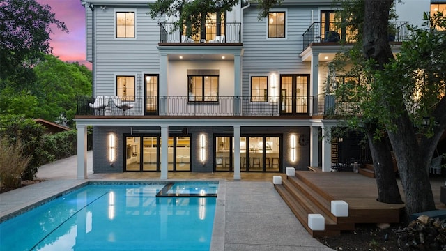 4203 Balcones Dr, Austin, TX 78731 - rear view of property with a balcony, a pool with connected hot tub, a patio, and brick siding