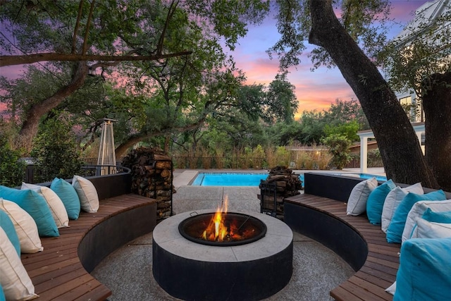 4203 Balcones Dr, Austin, TX 78731 - patio terrace at dusk with a wooden deck, a fenced backyard, and an outdoor living space with a fire pit