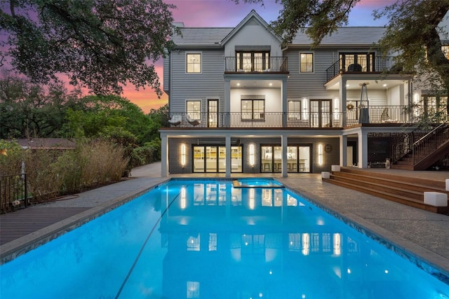 4203 Balcones Dr, Austin, TX 78731 - rear view of property featuring a balcony, a patio area, stairway, and an outdoor pool