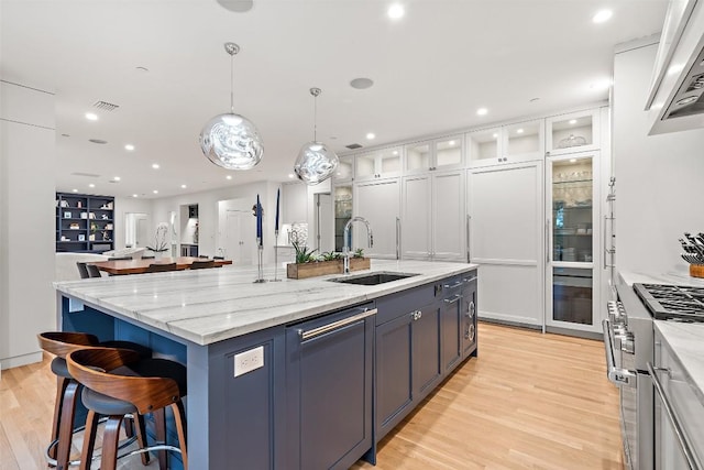 4203 Balcones Dr, Austin, TX 78731 - kitchen with high end stove, a sink, dishwasher, light wood-style floors, and white cabinetry