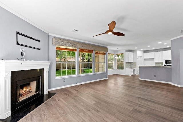 1809 Johnson Way, Round Rock, TX 78681 - unfurnished living room with a ceiling fan, dark wood-style flooring, ornamental molding, visible vents, and a lit fireplace