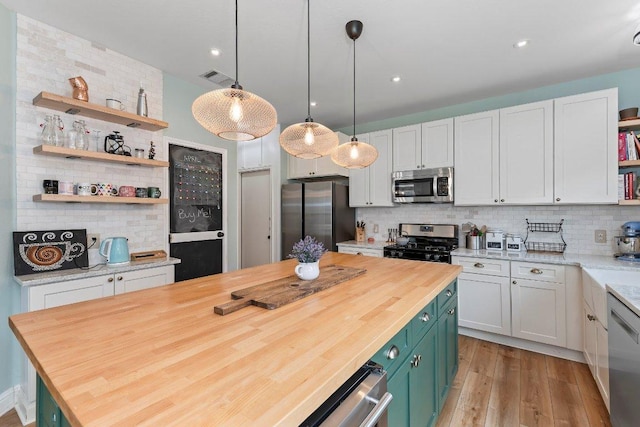 kitchen featuring open shelves, butcher block counters, backsplash, and stainless steel appliances