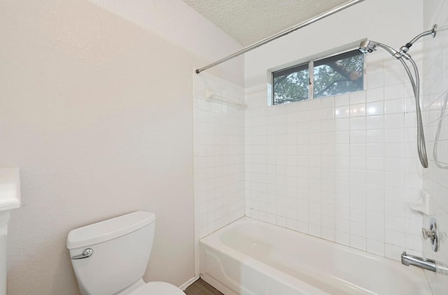 bathroom featuring shower / bath combination, a textured ceiling, and toilet