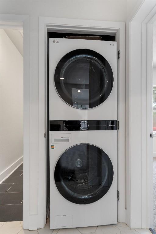 washroom featuring baseboards and stacked washer and clothes dryer