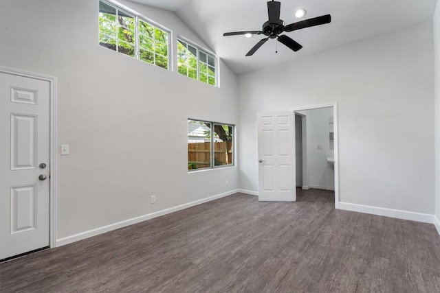 interior space with baseboards, a ceiling fan, dark wood-type flooring, and high vaulted ceiling