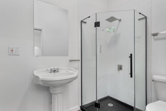 full bathroom featuring a stall shower and toilet