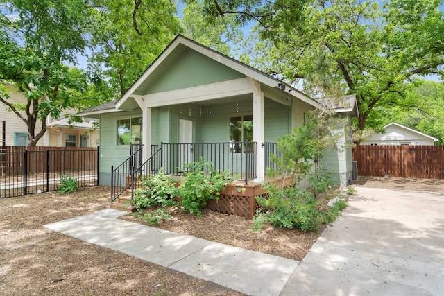 bungalow-style house with a porch and fence