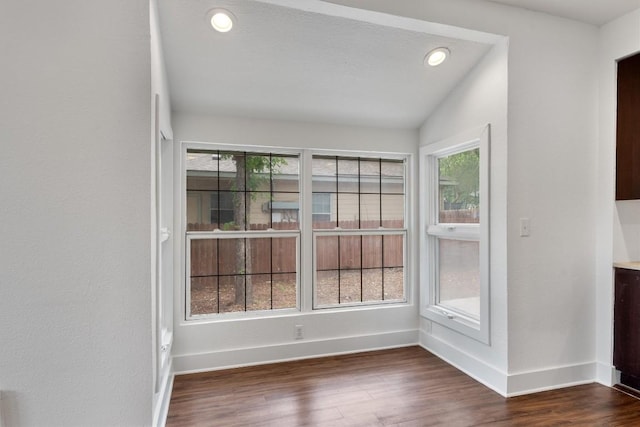 unfurnished dining area featuring recessed lighting, baseboards, vaulted ceiling, and dark wood-style floors
