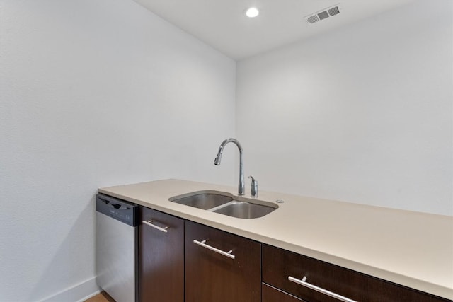 kitchen with dark brown cabinetry, a sink, dishwasher, light countertops, and visible vents