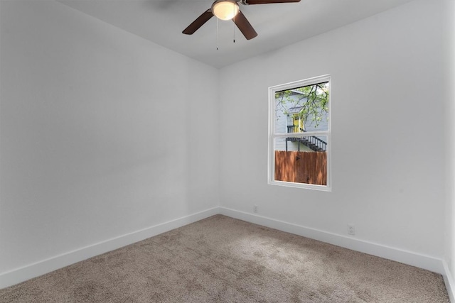 empty room featuring carpet floors, baseboards, and ceiling fan