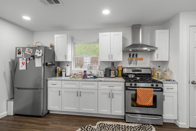 500 Capitol Dr Unit 1, Austin, TX 78753 - kitchen featuring visible vents, white cabinetry, wall chimney exhaust hood, light countertops, and appliances with stainless steel finishes