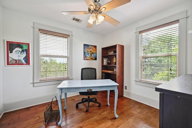 office featuring plenty of natural light, wood finished floors, baseboards, and a ceiling fan