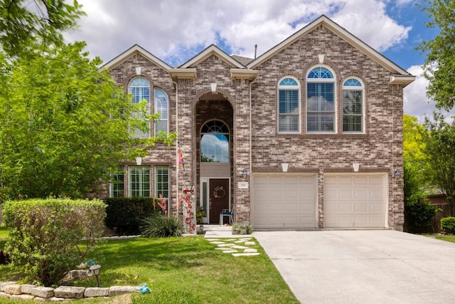 376 Sweet Gum Dr, Kyle, TX 78640 - view of front of house featuring concrete driveway, an attached garage, a front lawn, and brick siding