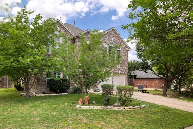 376 Sweet Gum Dr, Kyle, TX 78640 - view of front of home with concrete driveway, cooling unit, brick siding, and a front yard