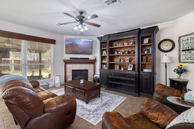 376 Sweet Gum Dr, Kyle, TX 78640 - living room with ceiling fan, a fireplace, tile patterned floors, and crown molding