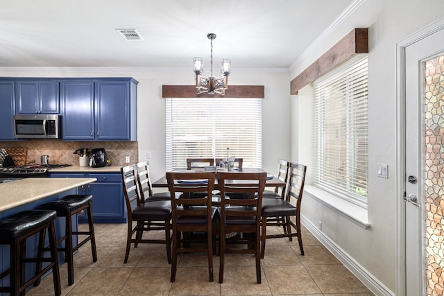 376 Sweet Gum Dr, Kyle, TX 78640 - dining space with a chandelier, healthy amount of natural light, light tile patterned floors, ornamental molding, and baseboards