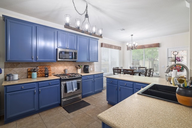 376 Sweet Gum Dr, Kyle, TX 78640 - kitchen featuring appliances with stainless steel finishes, blue cabinetry, a sink, a chandelier, and tasteful backsplash