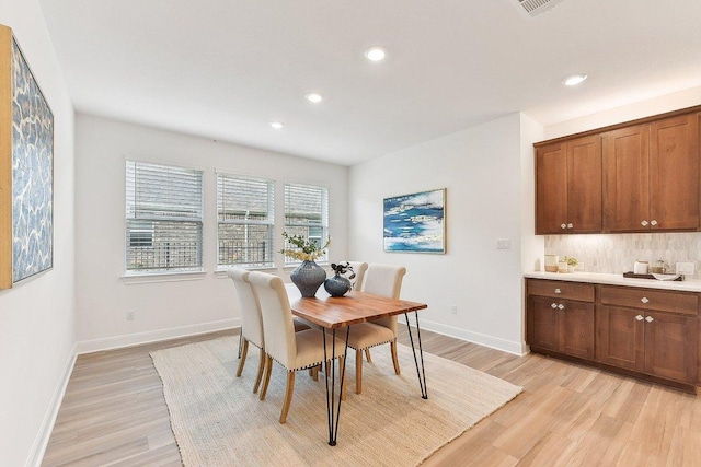 dining room with recessed lighting, baseboards, and light wood-style floors