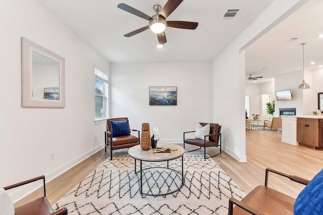 living area featuring visible vents, baseboards, recessed lighting, a ceiling fan, and light wood finished floors