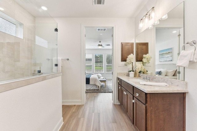 ensuite bathroom with walk in shower, visible vents, ensuite bathroom, and wood finished floors