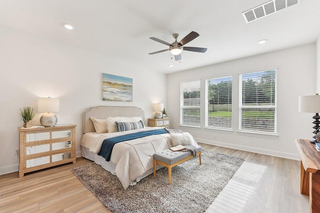 bedroom with ceiling fan, baseboards, visible vents, and light wood-style flooring