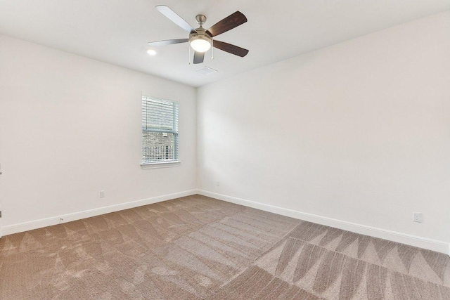 carpeted empty room featuring baseboards, a ceiling fan, and visible vents