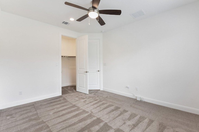 unfurnished bedroom featuring baseboards, ceiling fan, carpet, and visible vents