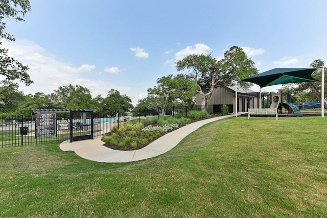 surrounding community with a lawn, fence, and playground community