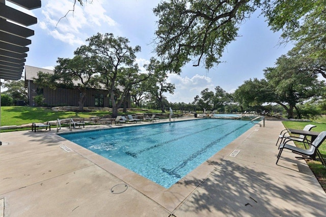 community pool featuring a yard and a patio area