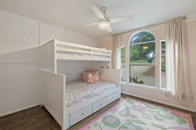bedroom with baseboards, ceiling fan, and dark wood-style floors