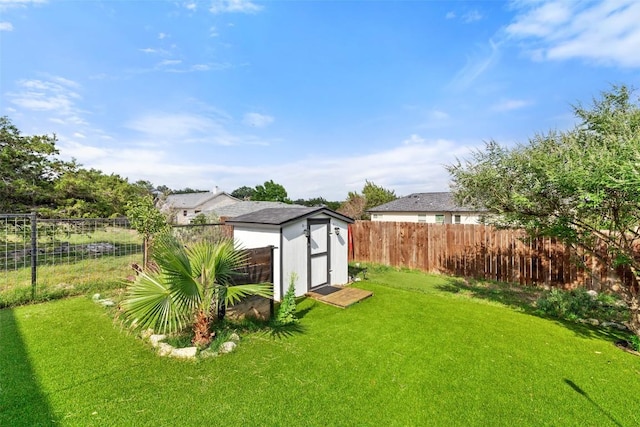 view of yard with a storage unit, a fenced backyard, and an outdoor structure