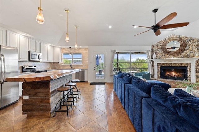 kitchen with open floor plan, a wealth of natural light, wooden counters, and stainless steel appliances