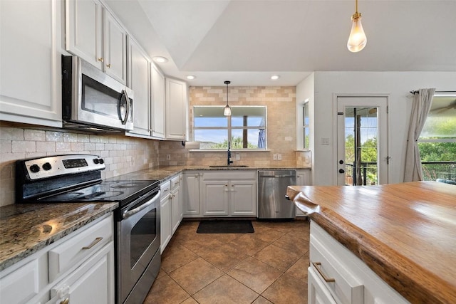 kitchen with a sink, decorative backsplash, appliances with stainless steel finishes, and white cabinetry