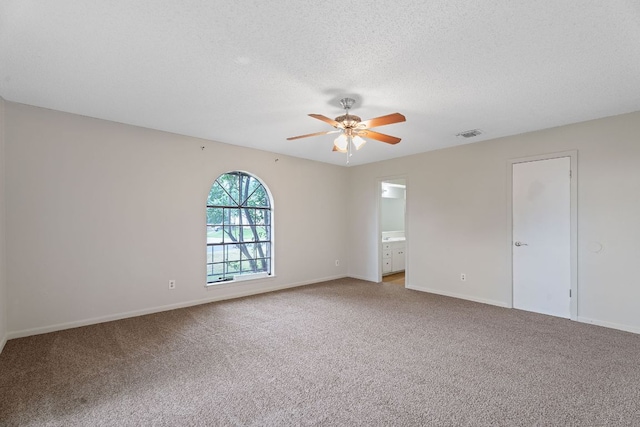 empty room with baseboards, visible vents, a ceiling fan, and light colored carpet
