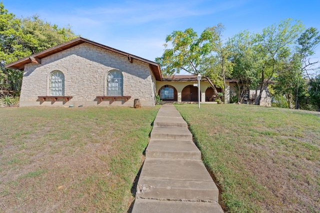 view of front of property featuring a front lawn and stone siding