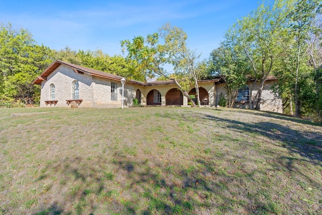 view of front of house with stone siding and a front yard