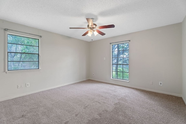 spare room with baseboards, carpet, a ceiling fan, and a textured ceiling