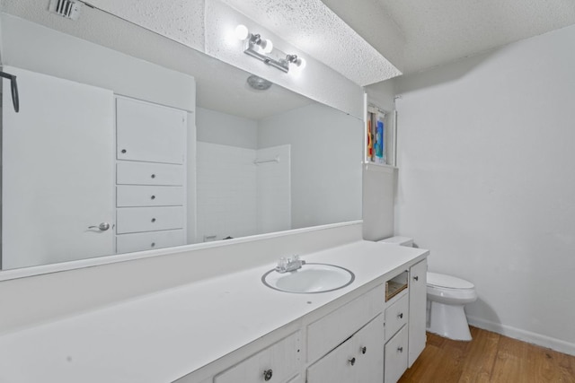 full bathroom featuring vanity, toilet, wood finished floors, a shower, and visible vents