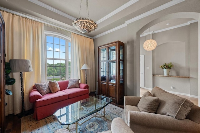 living room featuring arched walkways, wood finished floors, a chandelier, and ornamental molding
